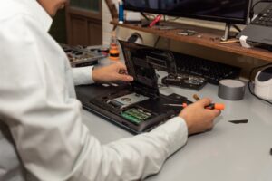 Computer repair technician repairing a laptop