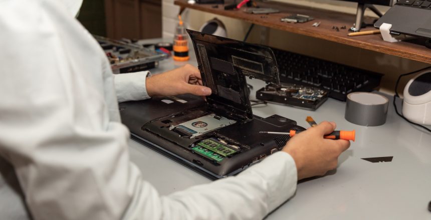 Computer repair technician repairing a laptop Computer repair technician repairing a laptop