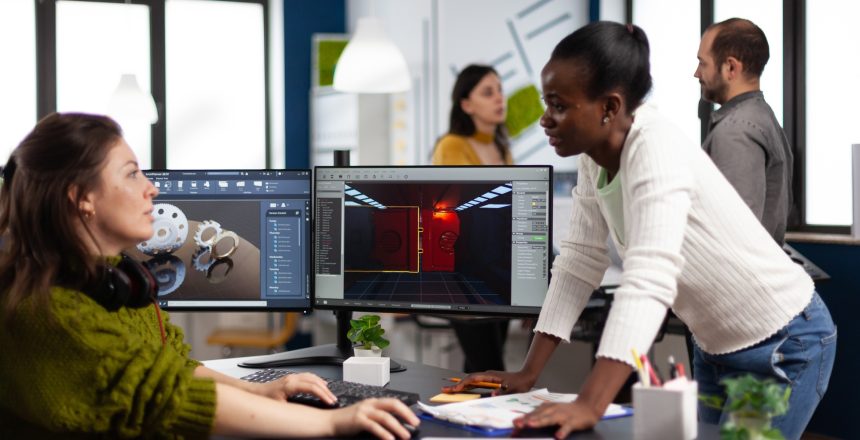 Multiethnic women game designer looking at computer
